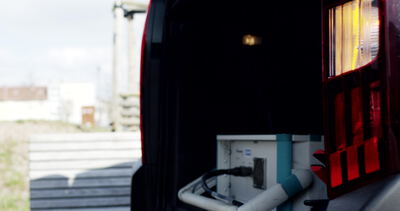 Techniker verbindet ein Stromkabel am Heck eines Servicefahrzeugs