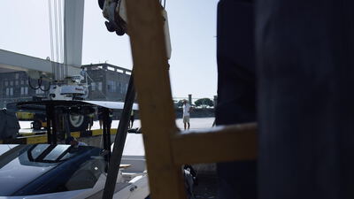 Motorboot hängt in den Hebegurten eines Bootskrans an der Werft am Hafen