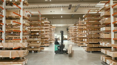 Schubmaststapler transportiert Ware im Hochregallager, Lagerhalle, Kragarmregal und Gabelstapler im Lager als 4K Stockvideo