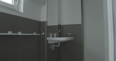 Modernes Badezimmer mit wandhängendem Waschbecken und Spiegel
