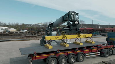 Ladekran mit Lastmagnet hebt eine Stahlplatte auf einen Tieflader Ladekran mit Lastmagnet hebt eine Stahlplatte auf einen Tieflader, Verladung, Schwerlasttransport und Stahlblech als 4K