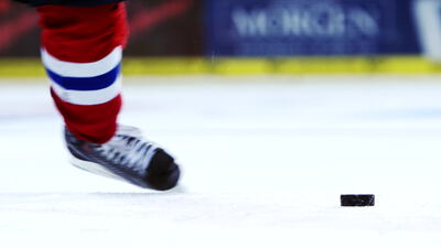Eishockeyspieler jagt den Puck über das Eis in Nahaufnahme
