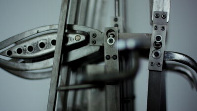 Perforiertes Metallbauteil in einer mechanischen Prüfmaschine