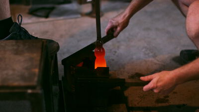 Glasmacher drückt glühendes Glas in den Formklotz Glasmacher drückt glühendes Glas in den Formklotz, Glasmacher bei der Arbeit, Formklotz für Glas und glühender Glasposten