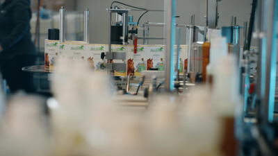 Ölflaschen an einer Etikettiermaschine im Werk