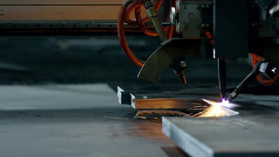 CNC Plasmaschneider trennt eine Stahlplatte mit sprühenden Funken