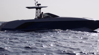Dunkle Motoryacht gleitet bei diesigem Gegenlicht über das offene Meer