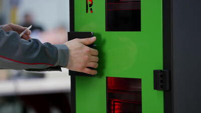 Mitarbeiter öffnet den grünen Lagerturm am Griff Mitarbeiter öffnet den grünen Lagerturm am Griff, Mitarbeiter am Lagerschrank, grüner Lagerturm und Schrank öffnen als 4K