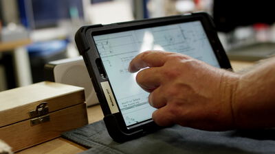 Hand bedient robustes Tablet mit technischer Zeichnung in der Werkstatt