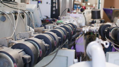 Industriemaschine bewegt schwarze Walzeneinheiten in der Fertigungshalle