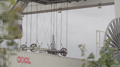 Containerkran hebt Frachtcontainer am Umschlagterminal, Container Verladung, Containerbrücke und Spreader Kran als 4K