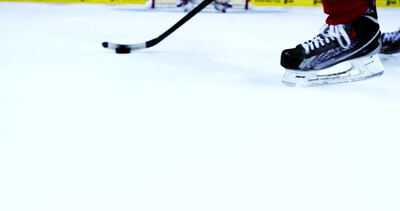 Eishockeyspieler führt den Puck über das Eis