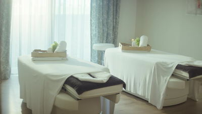 Leerer Massageraum mit zwei Behandlungsliegen im hellen Spa