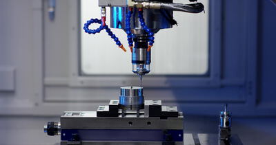 CNC Maschine bohrt ein Metallteil mit Kühlmittel