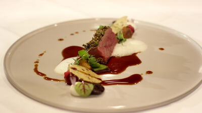 Gourmetteller mit rosa gebratenem Fleisch und dunkler Sauce