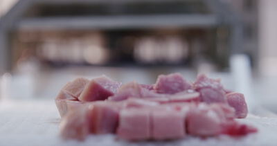 Rohe Fleischwürfel liegen auf der Arbeitsfläche der Produktionsküche