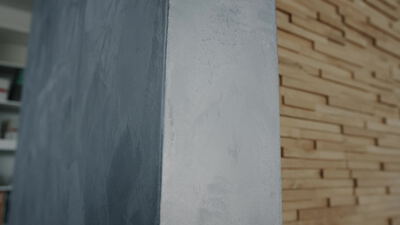 Moderne Innenwand mit Holzlamellen und dunklem Putz