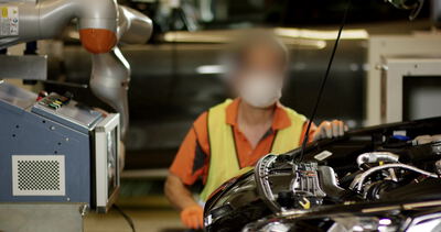 Arbeiter und Cobot bei der Motormontage im Automobilwerk