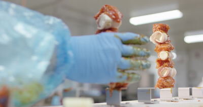 Fleischspieße werden in der Lebensmittelproduktion aufgesteckt