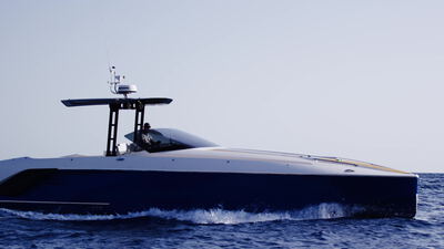 Dunkelblaue Motoryacht gleitet bei klarem Himmel über die ruhige See