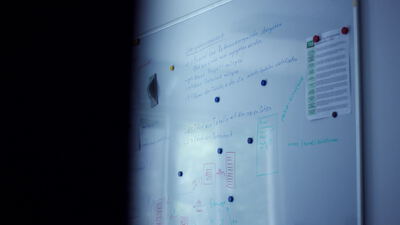 Whiteboard mit handschriftlichen Notizen und Haftnotizen im Büro Whiteboard mit handschriftlichen Notizen und Haftnotizen im Büro, Brainstorming, Projektplanung und Planungstafel als 4K