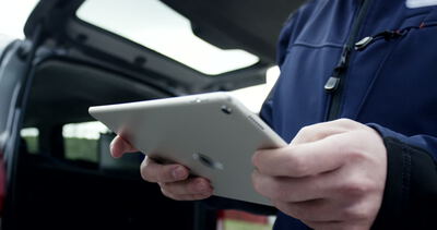 Techniker nutzt Tablet zur Dokumentation am Servicefahrzeug