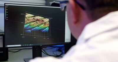 Wissenschaftler analysiert die dreidimensionale Oberflächenstruktur eines Materials am Monitor