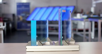 Zwei Glasplatten in einer Metallhalterung auf einem Arbeitstisch in einer Werkstatt
